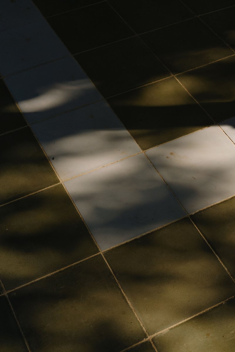 Diagonal shadows crossing a gridded stone floor in afternoon light