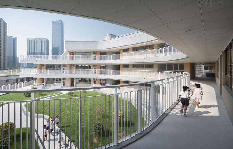 Covered walkway overlooking a central lawn with students walking below