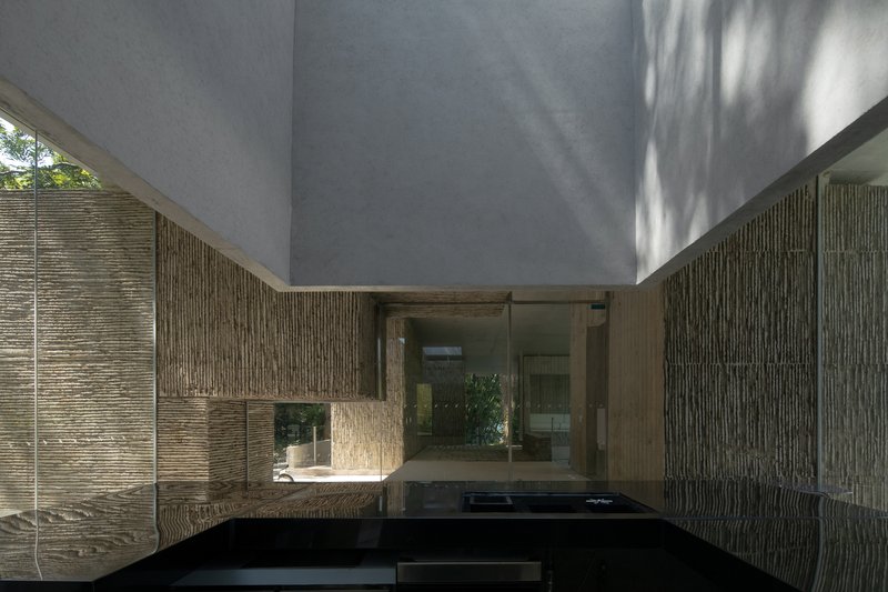 Interior courtyard with reflecting pool flanked by textured stone walls and an open concrete ceiling