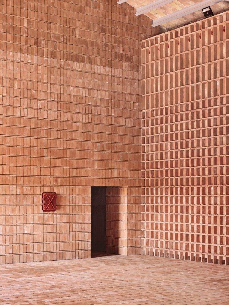 Corner view of doorway in terracotta brick wall with alternating open and solid coursing patterns
