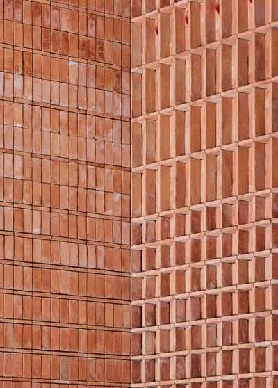 This architectural image showcases a brick facade with a unique design. The wall is constructed with