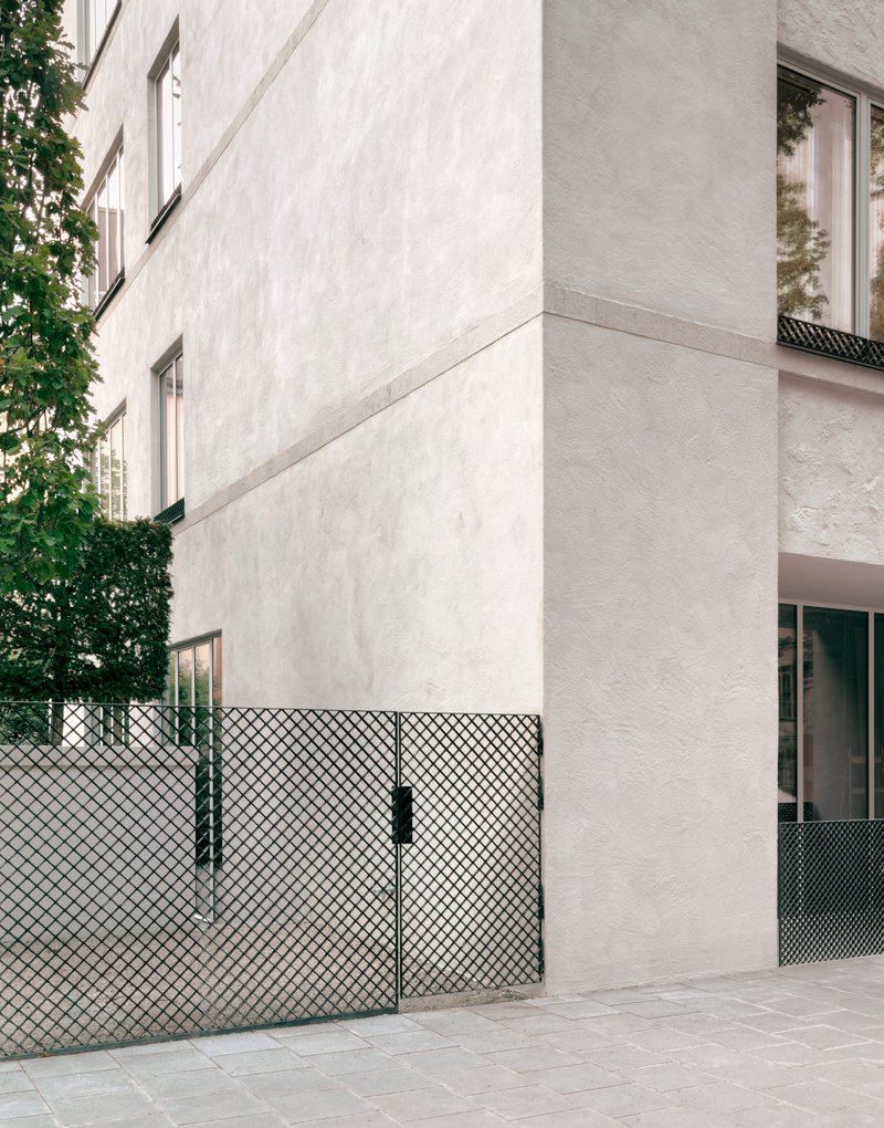 Exterior corner detail showing the white stucco wall meeting the diamond mesh balcony railing