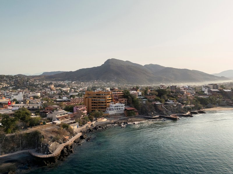 Aerial view of the coastal development with mountains in the distance at dusk