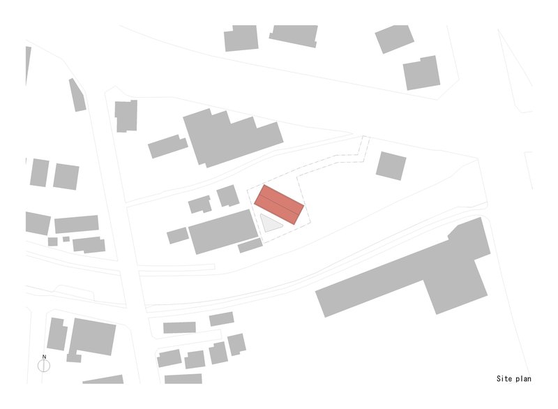 Site plan drawing showing a single highlighted building footprint among surrounding context in a neighborhood layout