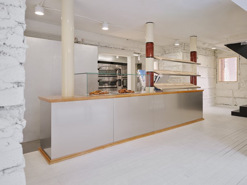 Bakery service counter with the oven visible behind and trays of bread on the back shelf