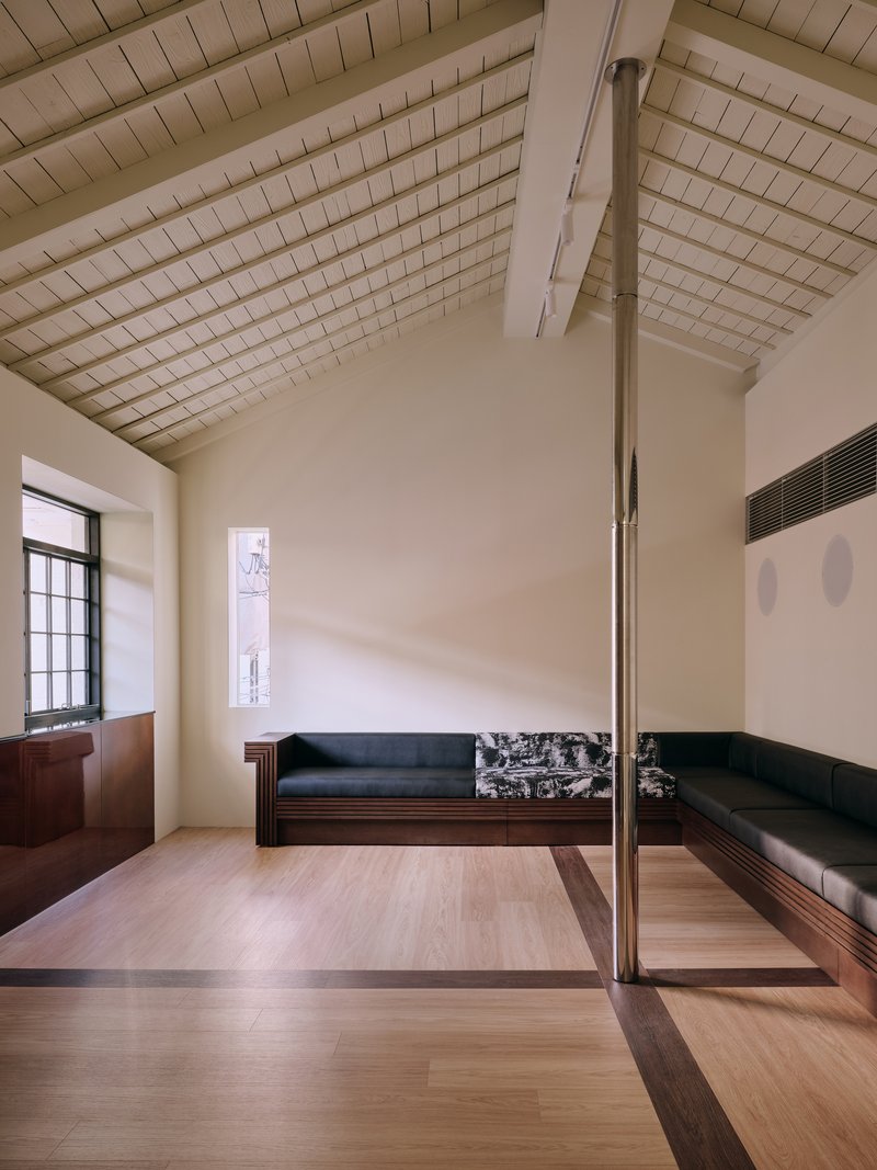 Quiet seating room with a steeply pitched white tile ceiling and benches along two walls