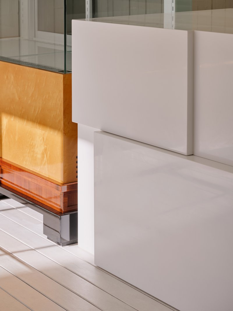 Close-up of the ribbed white counter base meeting a wood-and-glass cabinet
