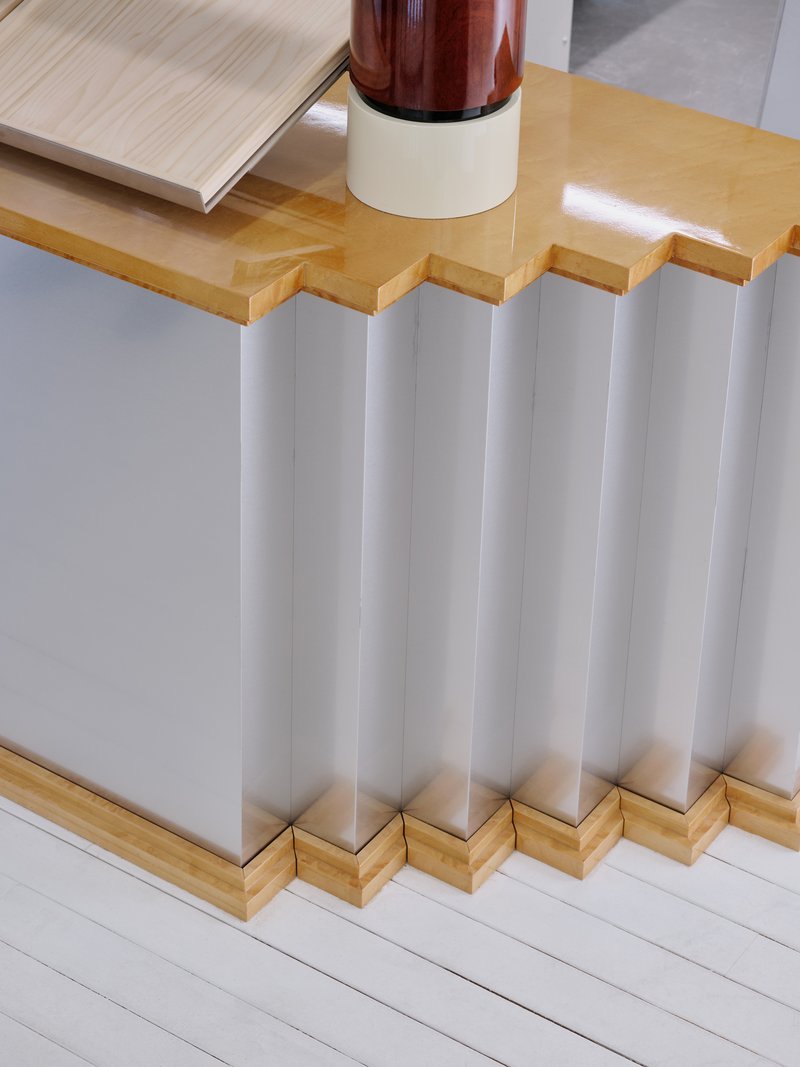 Detail of the corrugated metal counter base with a timber top and a glass display above