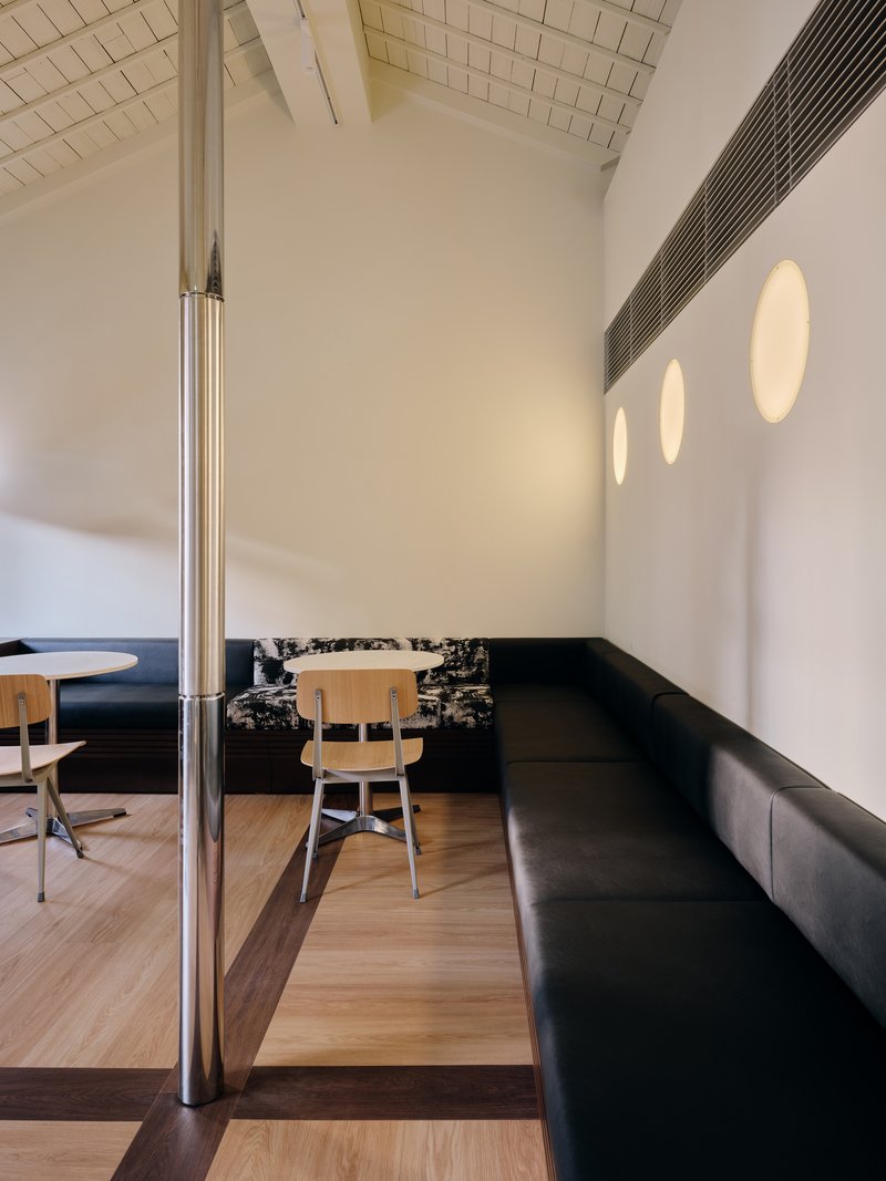 Long bench seating against a wall with three circular wall lights