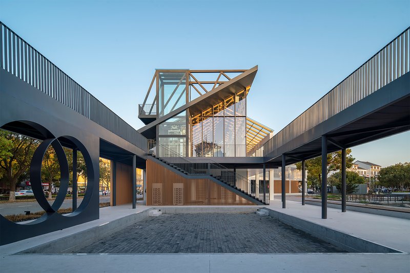 View through the covered walkway framing the elevated timber structure at dusk