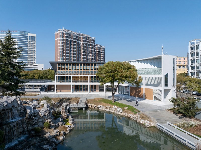 Campus view across the pond with rocky edges and residential towers in the background