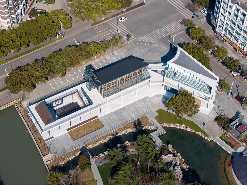Aerial view of the white-roofed complex surrounded by waterways and landscaped green spaces with trees