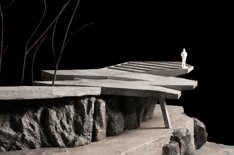 Detail of the model showing a curved deck with stairs bridging over the rocky terrain