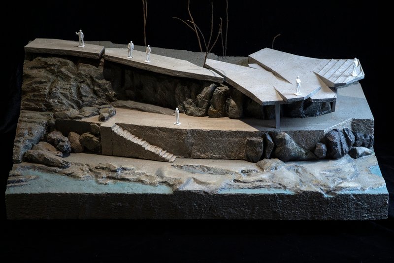 Overall view of the physical model set on a base showing the waterfront and rocky landscape