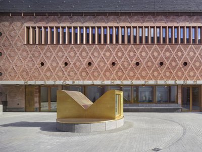 The image showcases the facade of a historical museum, characterized by its intricate brickwork feat