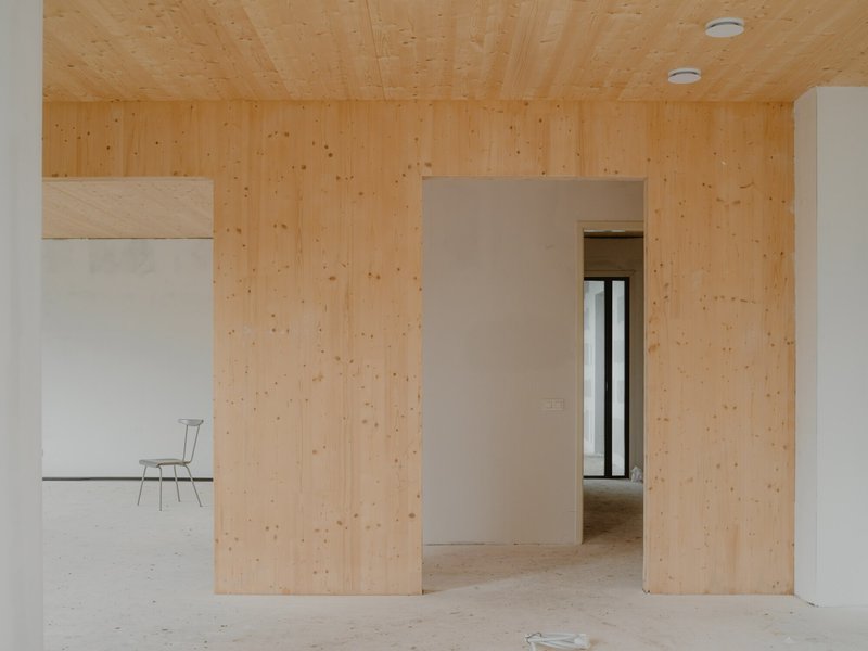 Interior doorway framed by light plywood walls and ceiling with view through to adjacent room