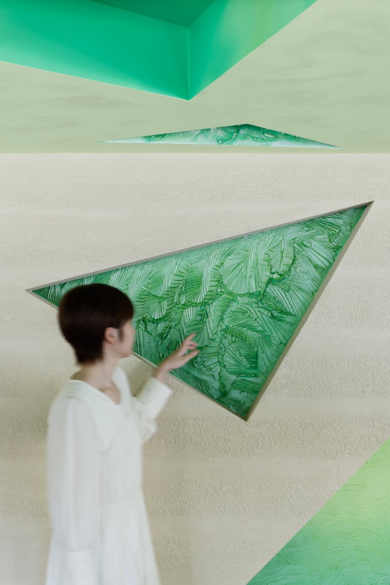Detail of a triangular wall inset filled with a textured green leaf pattern