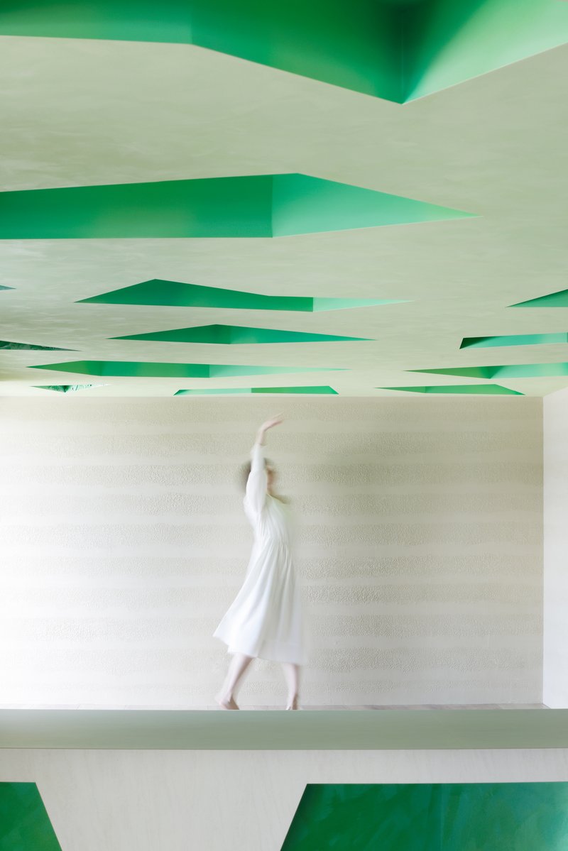 Motion-blurred figure walking past the carved-out ceiling and a sculpted bench