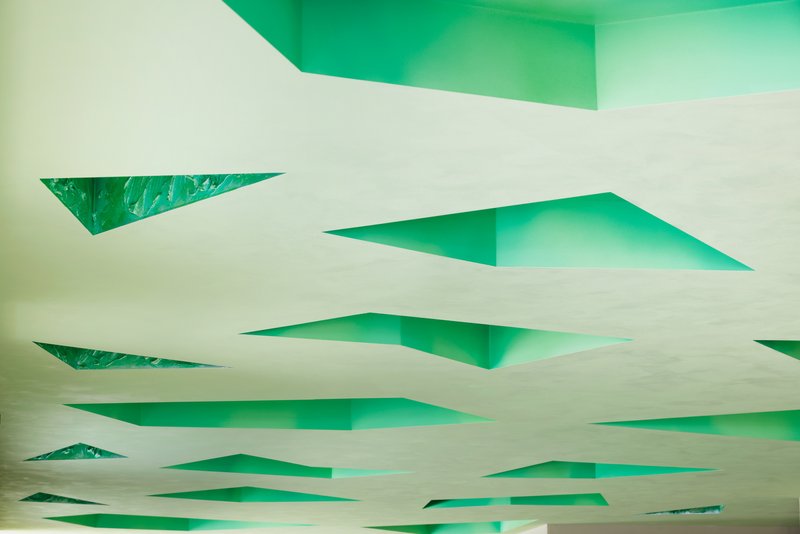 Looking up at the ceiling cavities painted in saturated green from below