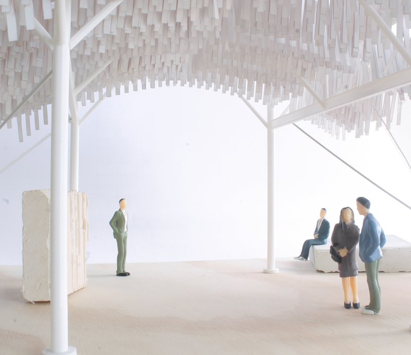 Interior view of the model showing white structural columns, vertical hanging elements, and grouped miniature figures