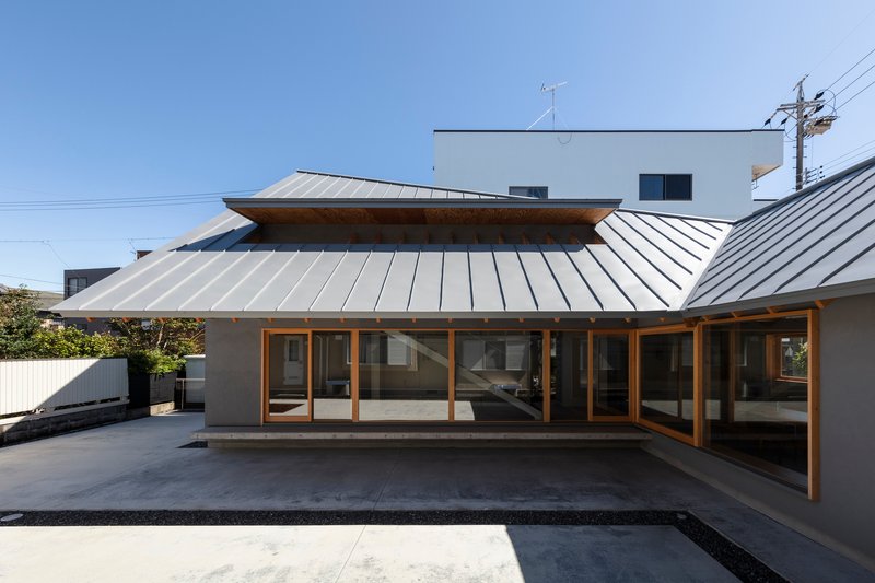 Courtyard view of the standing seam metal roof canopy with timber framing over full-height glazed doors