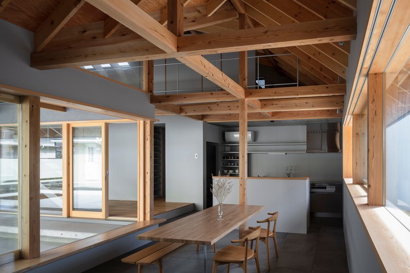 Dining area with exposed timber post-and-beam structure and skylights illuminating the wood ceiling