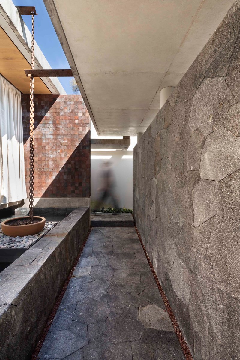 Narrow side passage with stone-clad wall and a stone-floor path leading to the rear