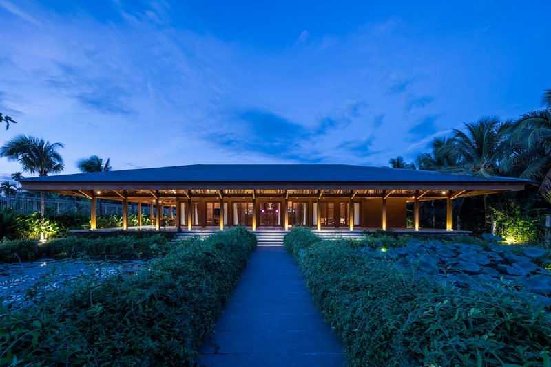 Garden approach to the pavilion at twilight with pathway through planted beds