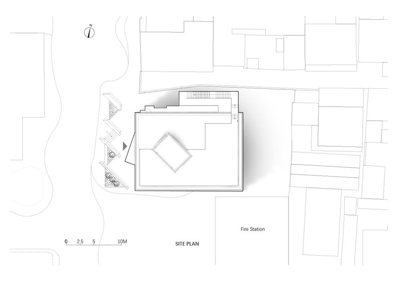 Site plan drawing showing the building footprint with diamond-shaped element among surrounding structures