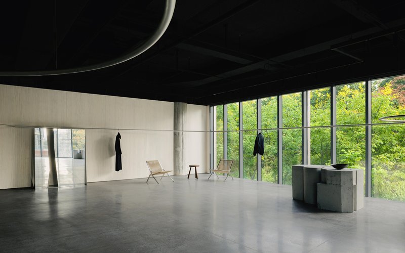 Polished concrete floor reflecting daylight from glazed walls overlooking trees in leaf