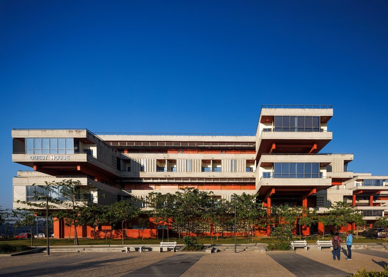 Frontal view of the guest house from the entrance plaza with the GUEST HOUSE signage on the eaves