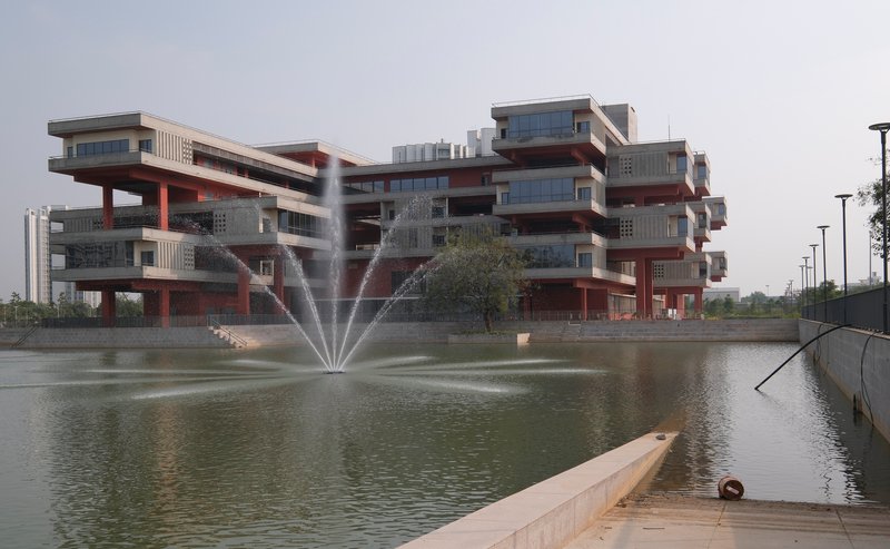View of the guest house from across the campus reflecting pool with a fountain in the foreground