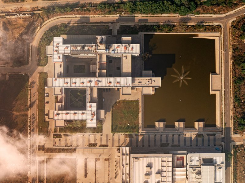 Top-down aerial showing the courtyards, the long lake, and the orthogonal plan