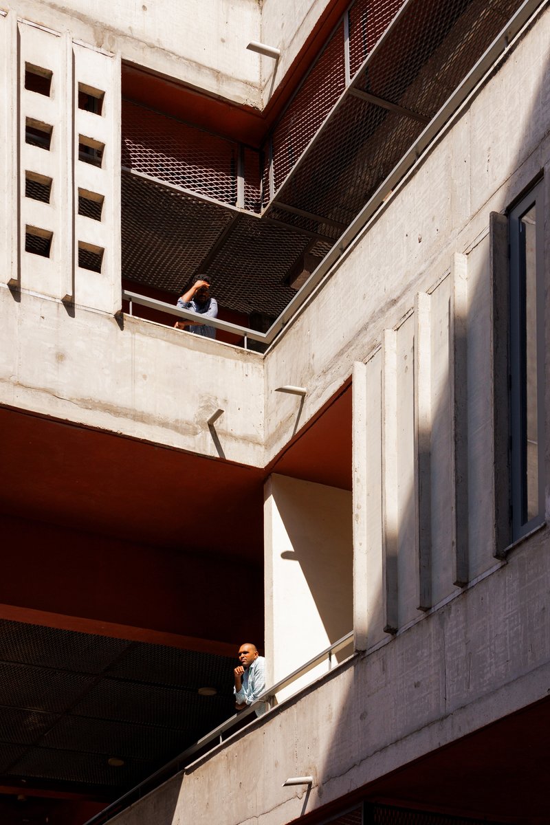 Concrete circulation balconies seen between the wings, with a figure on each level