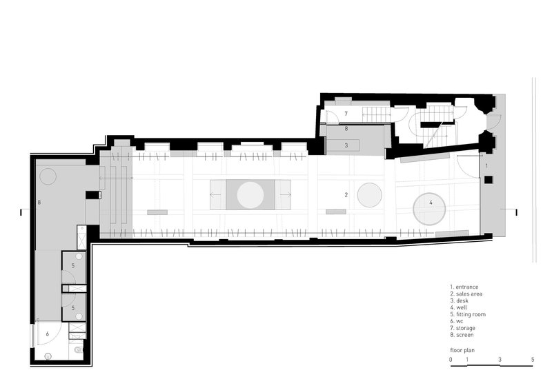 Floor plan showing an elongated retail space with two circular display zones and rear staircase