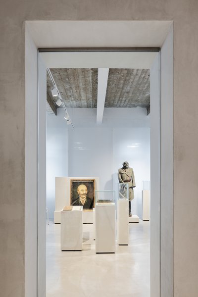 This architectural image showcases the interior of a museum or gallery space, viewed through a doorw