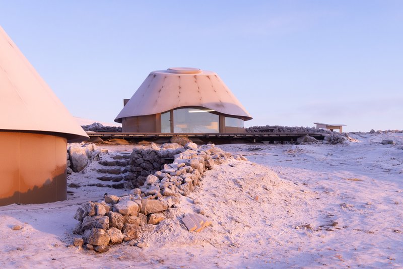 Low angle view of a domed unit on stone foundation with snow and ice in foreground
