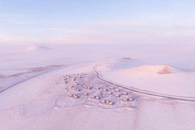 Drone view of the three-lobed settlement of dome structures in a misty snowfield
