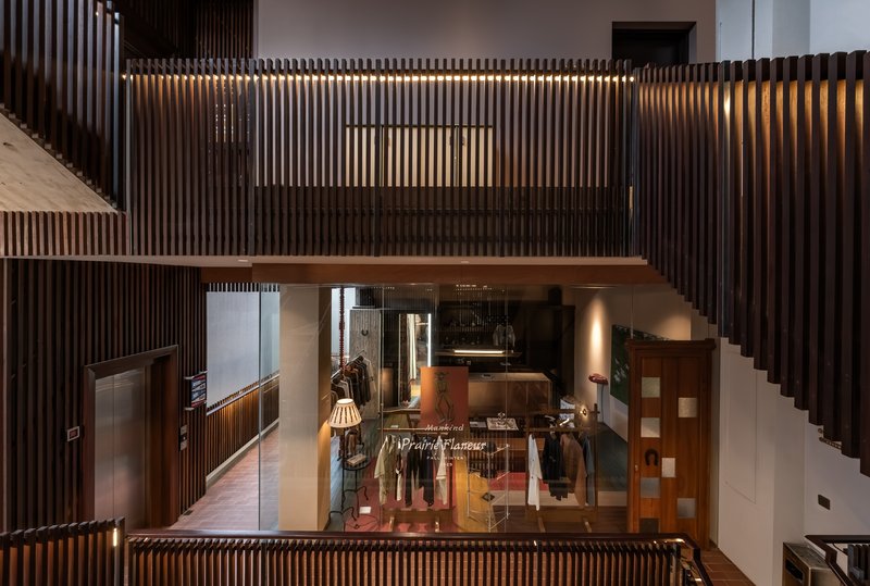 Interior view through slatted screens revealing retail display areas and circulation spaces at night