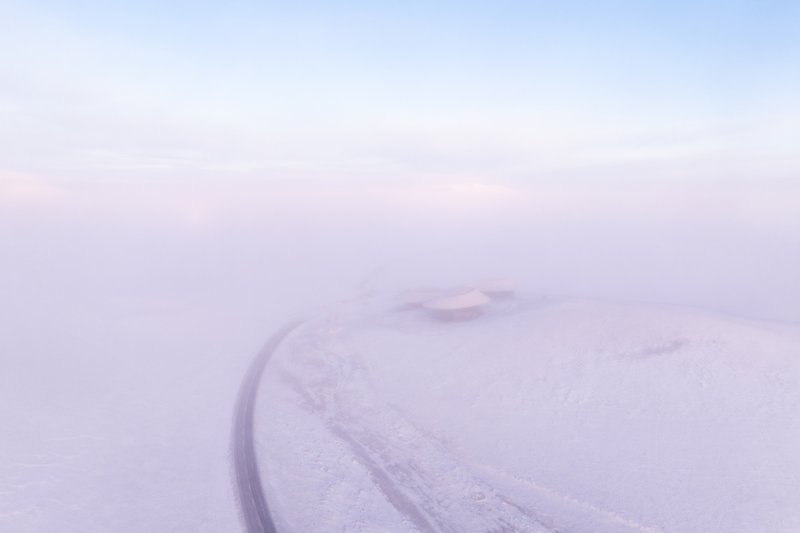 Misty distant view of the volcano cone with the road curving past it