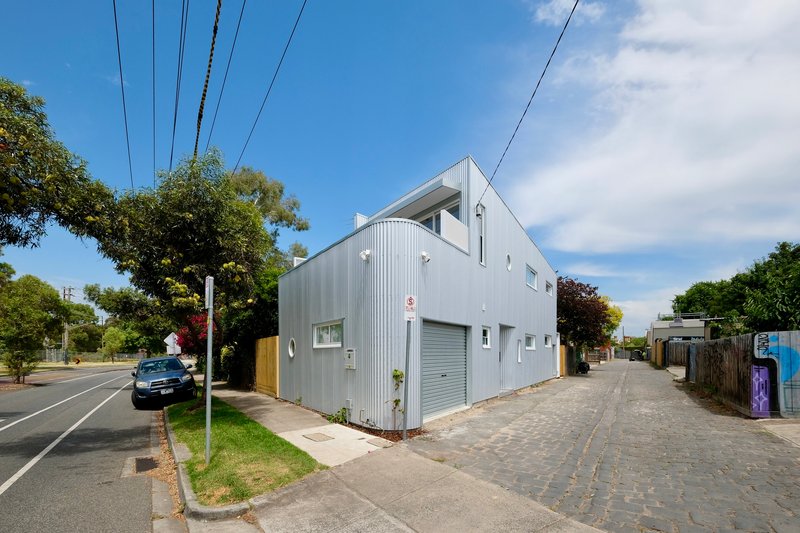 Corner view of the corrugated metal facade with timber fence and overhead power lines