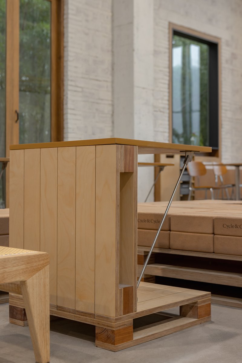 Corner detail of timber display cabinet with vertical slat cladding on polished concrete floor