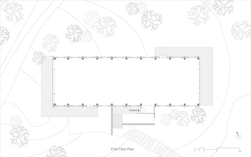 Site plan drawing showing a rectangular building footprint surrounded by trees with a stepped entrance approach