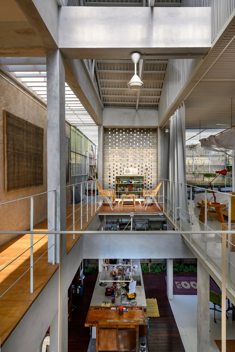 Vertical section through multi-level interior showing perforated brick screen, bridges, and open dining space below