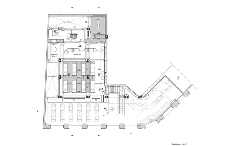 Floor plan drawing showing an angled layout with rows of seating, a central stair, and ancillary spaces