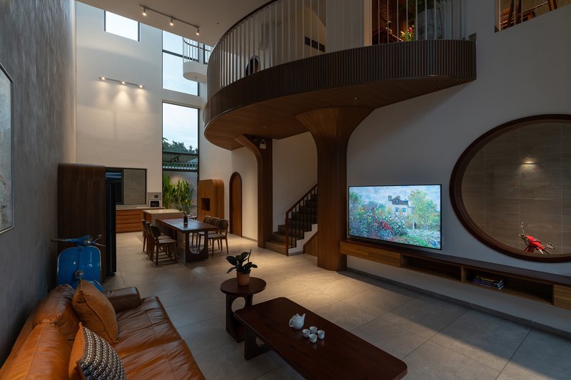 Double-height living area with timber mezzanine supported by curved columns and arched openings below