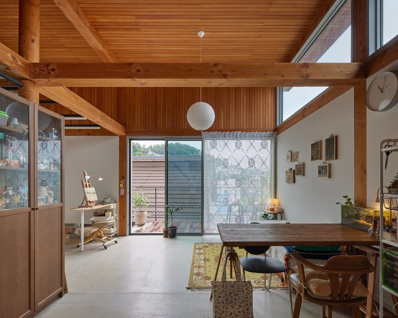 Interior with exposed timber beams and ceiling opening to a patterned screen wall and courtyard beyond