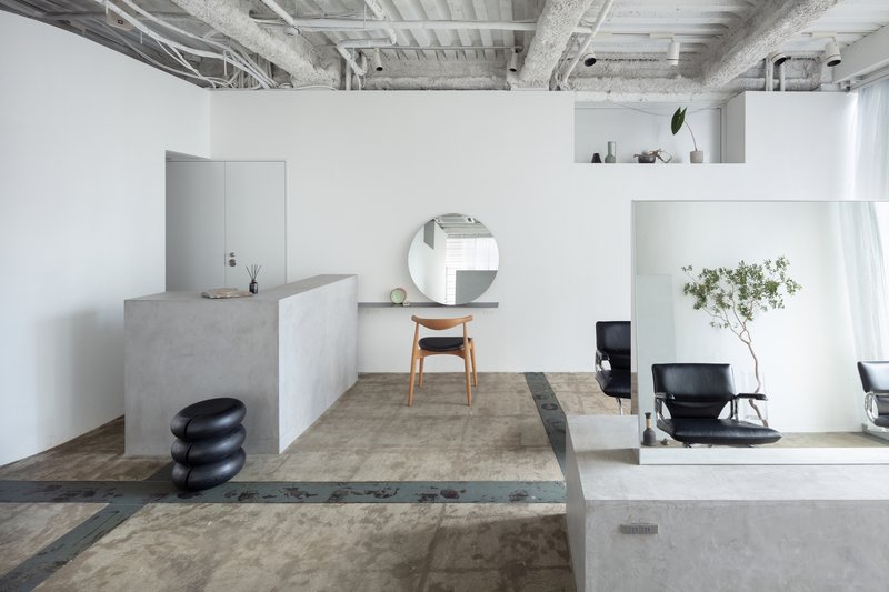 Split-level interior with concrete platforms and exposed ceiling beams under diffused daylight