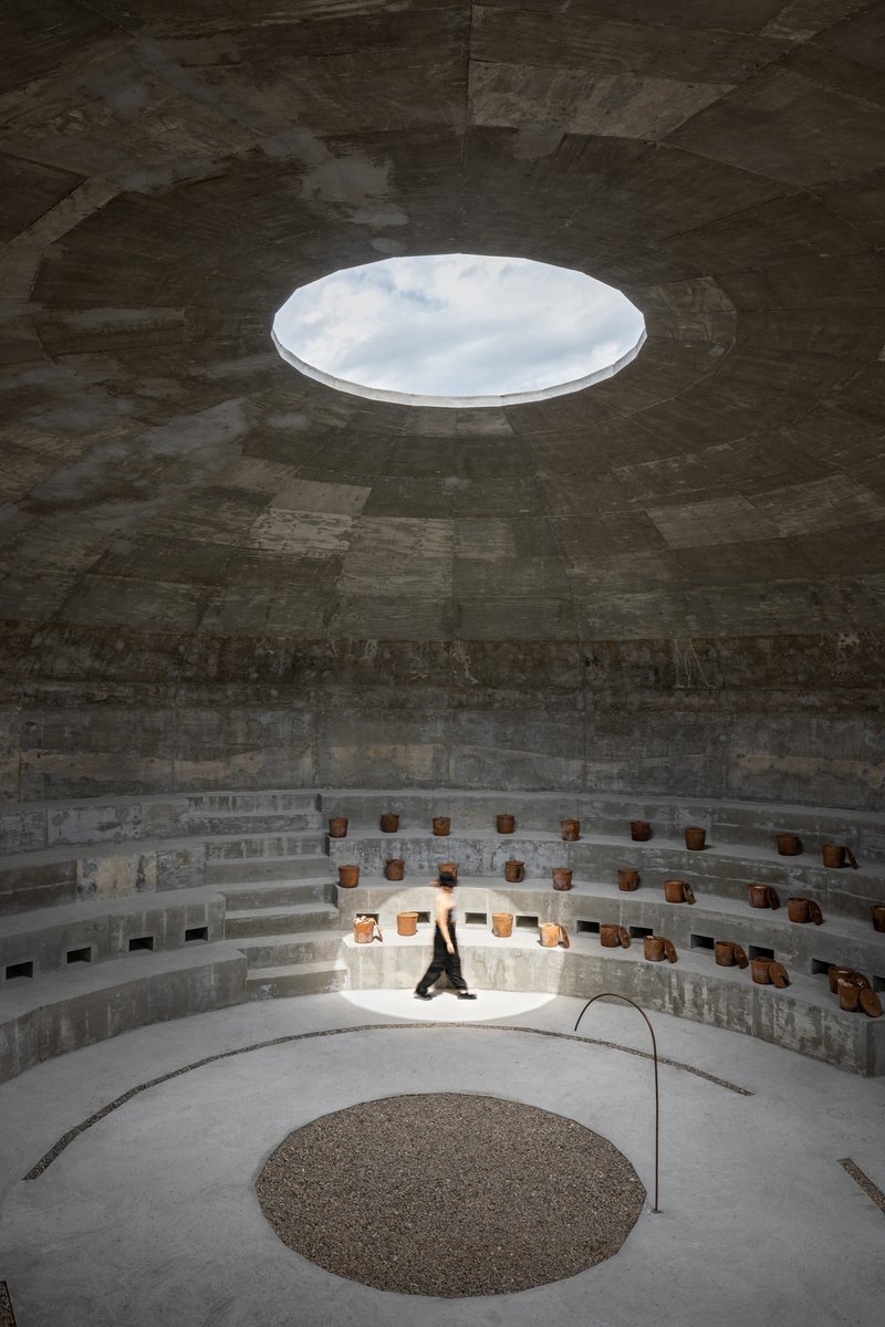 View up to the circular oculus in the dome ceiling with a figure seated on the lower benches