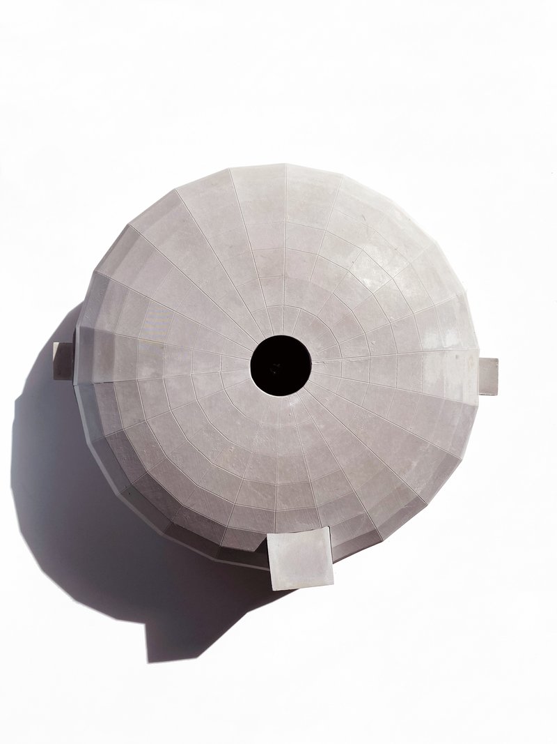 Top-down view of the circular dome roof showing radial concrete panels and central opening